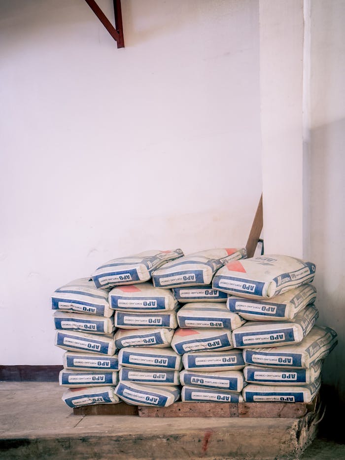 A stack of bags of cement neatly arranged in an indoor warehouse environment.